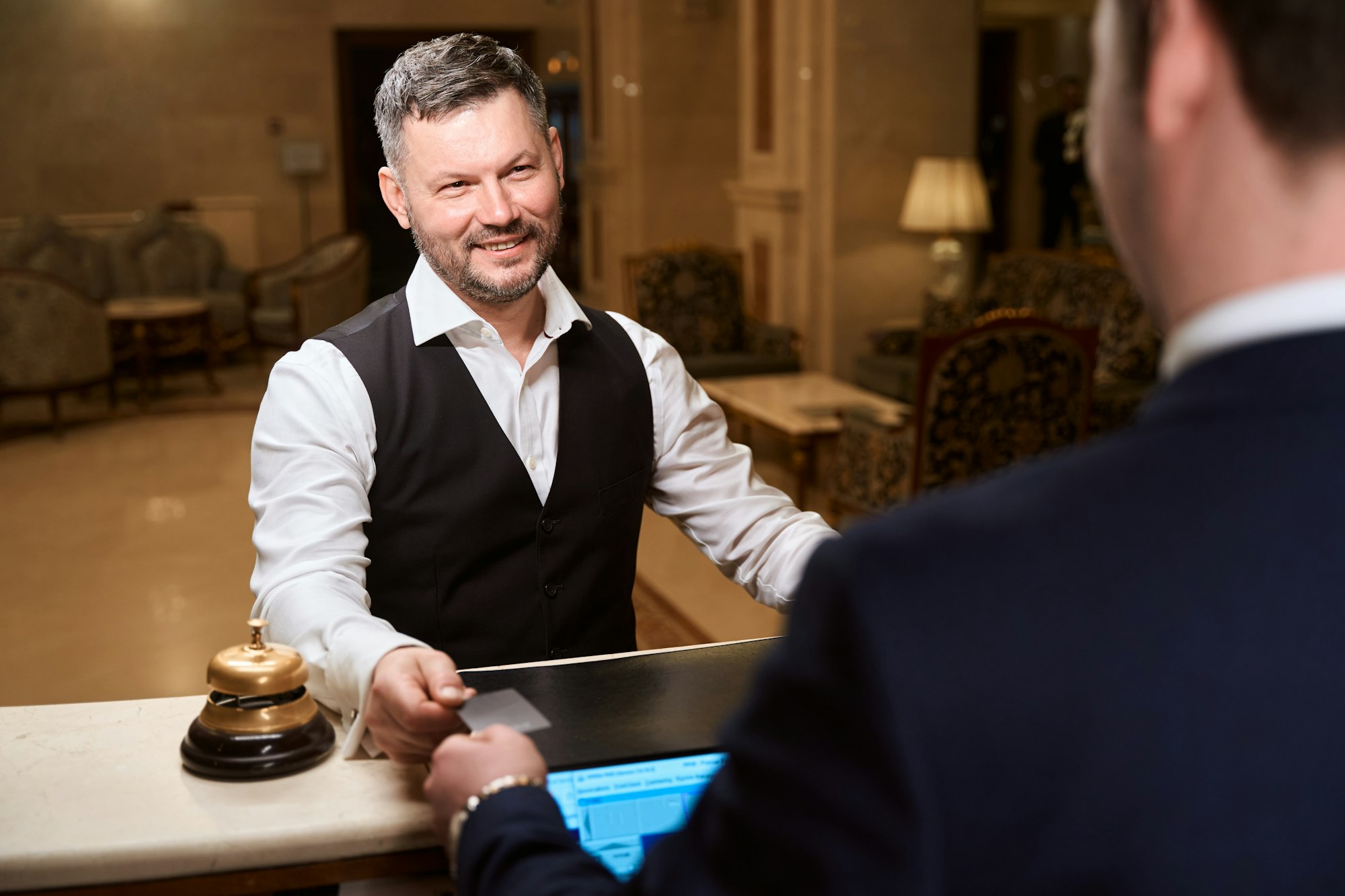 Handsome man giving credit card for paying service to receptionist in the hotel