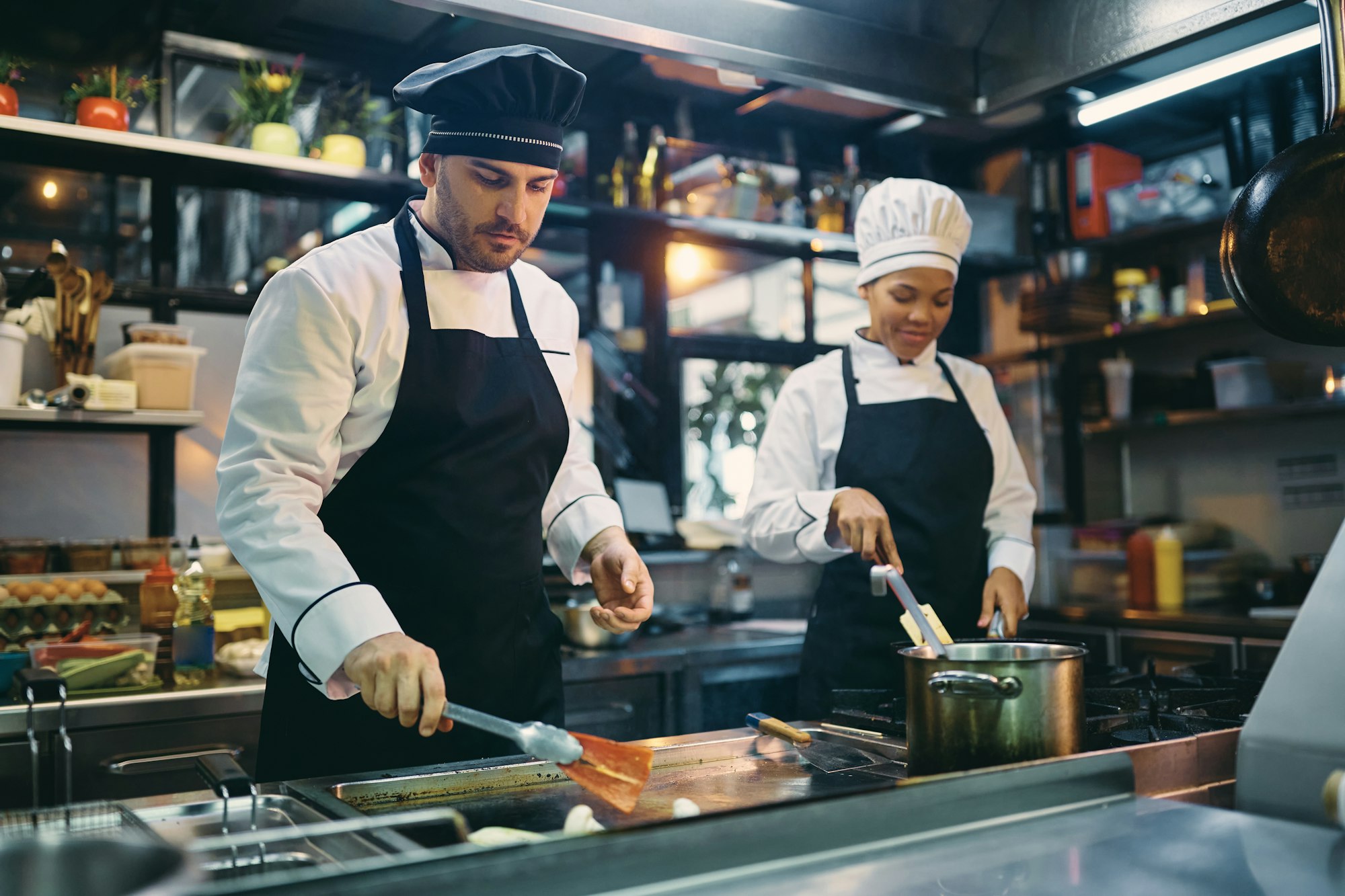 Two professional cooks working in the kitchen at restaurant.